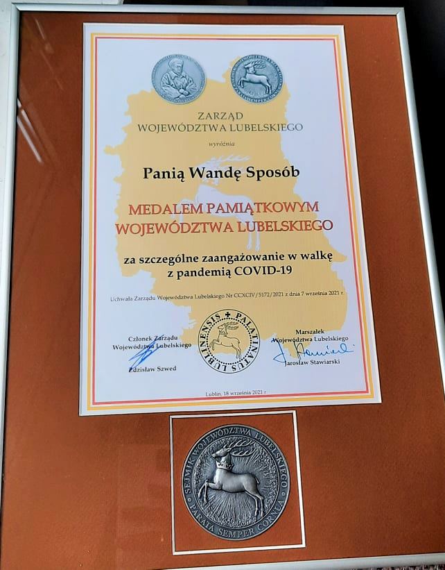 Dyplom Zarząd Województwa Lubelskiego wyróżnia Panią Wandę Sposób medalem pamiątkowym Województwa Lubelskiego za szczególne zaangażowanie w walkę z pandemią covid-19. Uchwała Zarządu Województwa Lubelskiego Ne CCXCIV/5172/2021 z dnia 7 września 2021 r. Podpisali: Jarosław Stawiarski - Marszałek Województwa Lubelskiego Zdzisław Szwed - Członek Zarządu Województwa Lubelskiego Lublin, 18 września 2021 r.